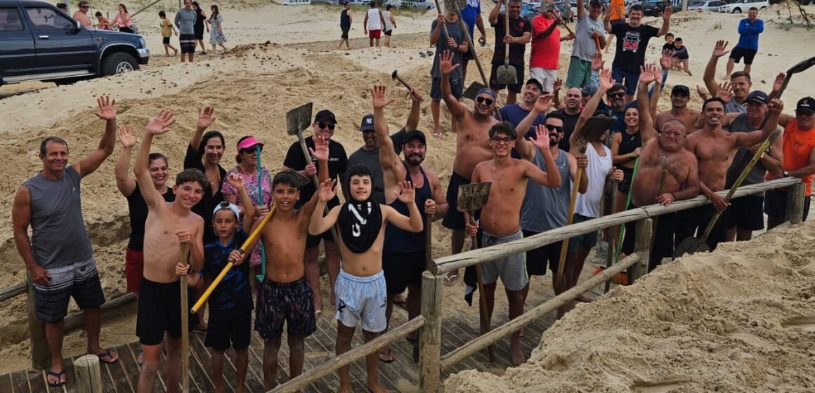 Voluntários desobstruem passarela na praia do Camacho