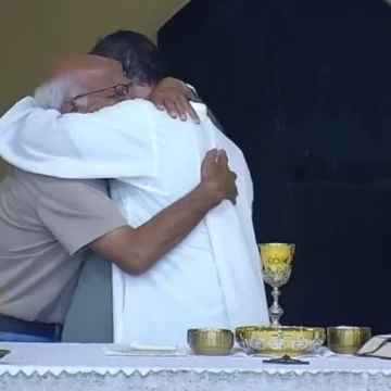 Avô que perdeu o neto abraça padre durante missa em Tubarão