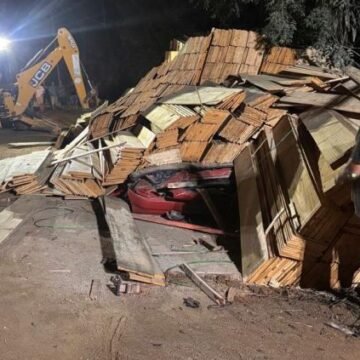 Casal morre na região após caminhão de madeira tombar sobre carro Casal morre na região após caminhão de madeira tombar sobre carro